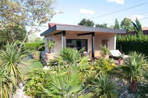 una casa con palmeras delante en Villa Margaux, en Fargues-Saint-Hilaire
