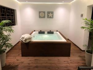 a jacuzzi tub in a room with plants at Ionian Eye Design Studios & Spa in Mesongi