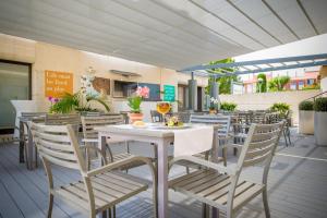 a patio with a white table and chairs at Atenea Park Suites & Apartments in Vilanova i la Geltrú