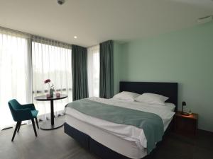 1 dormitorio con 1 cama y 1 mesa con silla en Lovely holiday home Walleken with a pond, en Eekhout