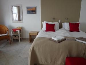 een slaapkamer met een groot bed met rode kussens bij Meike's Guesthouse in Swakopmund