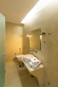 uma casa de banho com um lavatório, um WC e um espelho. em Mykonos Azure em Psarou