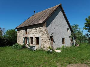 una pequeña casa de piedra en un campo de hierba en Charming holiday home overlooking the valley, en Lapeyrouse