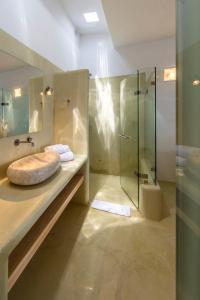 a bathroom with a sink and a glass shower at Mykonos Azure in Psarou