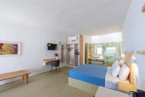 um quarto com uma cama azul e uma cozinha em Mykonos Azure em Psarou