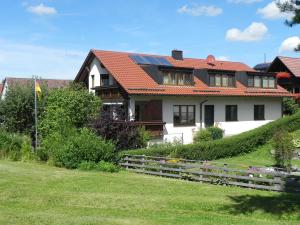 Casa blanca con techo rojo en Ferienwohnung Beck, en Münsingen