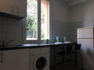 a kitchen with a washing machine and a window at Tra S.Orsola e Fiera in Bologna