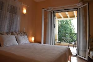 ヴァシリキにあるHeliotropia Housesのベッドルーム1室(ベッド1台付)、景色を望むバルコニーが備わります。
