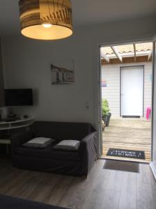 a living room with a couch and a sliding glass door at AUX PETITS BAGANAIS in Lacanau