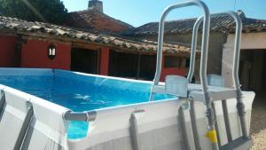 a swimming pool in front of a house at La Casa del Abuelo Simón in Fuente el Sauz