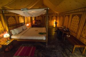 a bedroom with a bed with a canopy and a bench at The Barefoot At Havelock in Havelock Island