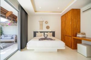 ケロボカンにあるVilla Love Umalasのベッドとガラスの引き戸のある寝室