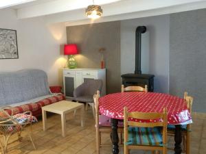 a living room with a table and a stove at Beautiful house with modern interior in Plounéventer