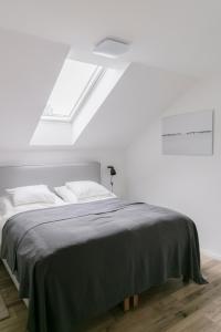 um quarto branco com uma cama com um cobertor preto em KRACHER Suite mit Nationalparkblick em Illmitz