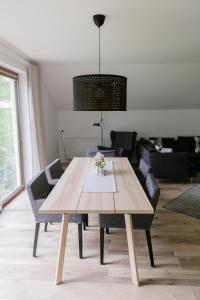 ein Esszimmer mit einem Holztisch und Stühlen in der Unterkunft KRACHER Suite mit Nationalparkblick in Illmitz