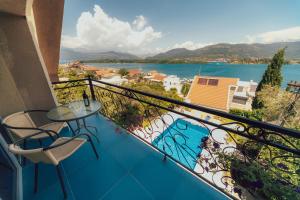 Un balcón con mesa y sillas y vista al agua. en Villa Tivat, en Tivat