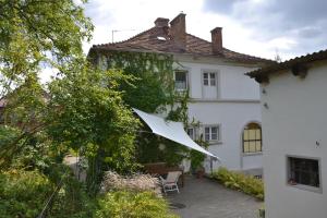 Biały dom z parasolką na podwórku w obiekcie Villarada w Łagowie