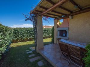 a patio with a table and chairs under a pergola at Villa Fiore con Piscina e Vista Mare in Palau