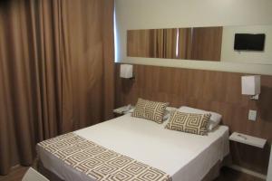 En eller flere senge i et værelse på Golden Suíte Hotel