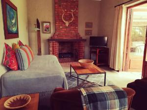 - un salon avec un canapé et une cheminée dans l'établissement Bluebell Barn, à Dullstroom