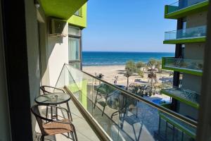 ein Balkon mit Tisch und Stühlen und der Strand in der Unterkunft Blue Apartment in Spa n Pool Beach resort in Mamaia Nord – Năvodari