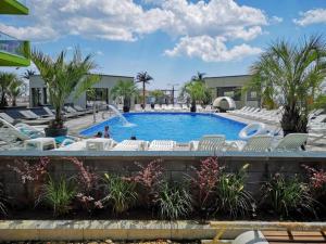 einen Pool in einem Resort mit Stühlen und Bäumen in der Unterkunft Blue Apartment in Spa n Pool Beach resort in Mamaia Nord – Năvodari