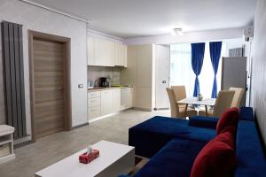 ein Wohnzimmer mit einer blauen Couch und einer Küche in der Unterkunft Blue Apartment in Spa n Pool Beach resort in Mamaia Nord – Năvodari