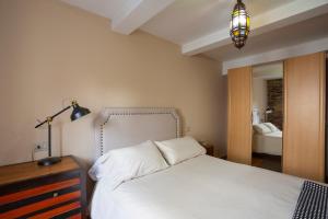 a bedroom with a white bed with a lamp and a mirror at Bed & Center in Lugo