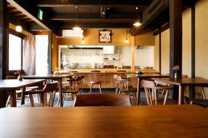 a restaurant with tables and chairs and a kitchen at Kariya Ryokan Q in Ako