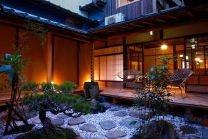 a patio with a table and chairs and a garden at Kariya Ryokan Q in Ako