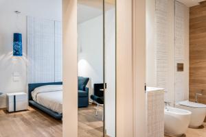 a bedroom with a bed and a bathroom with a tub at Resort Miramonti in Forte dei Marmi