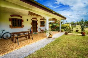 uma casa com um banco no quintal em Lovely Garden Villas em Pantai Cenang