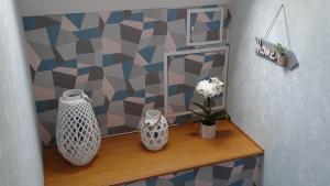 a shelf with vases and flowers on a wall at Chambres de Monthéard in La Bazoge