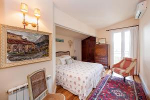 um quarto com uma cama e um quadro na parede em Casa Rural Mailan PARKING INCLUIDO em Orio