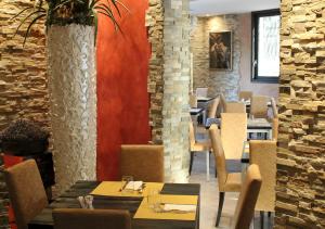 Quattro Gatti Rooms&Suite في Verdello: مطعم بطاولات وكراسي وجدار من الطوب