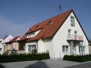 ein großes weißes Haus mit rotem Dach in der Unterkunft Pension Gästeparadies in Kleinkötz