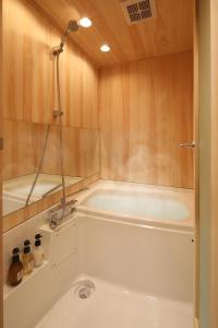 a bathroom with a bath tub with a shower at Kanade Kyoto-Hachijoguchi in Kyoto