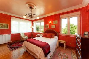 a bedroom with red walls and a bed and windows at Casa Rural Mailan in Orio