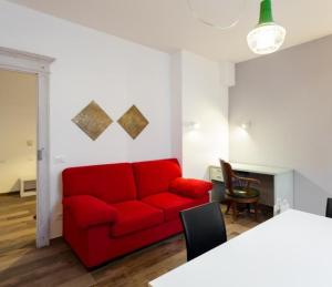 un soggiorno con divano rosso e tavolo di Appartamento Vo' 74 a Trento