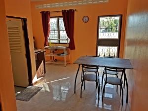 a dining room with a table and chairs and two windows at La Belle Cliff View in Ao Nang Beach