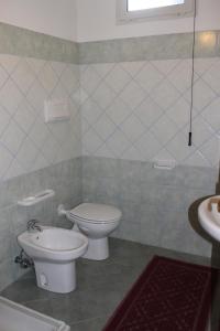 a bathroom with a toilet and a sink at Villa Vera in Cala Liberotto