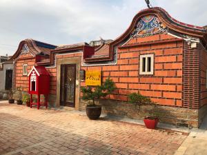 a small brick building with a sign on it at 八八古藝民宿 in Jinning