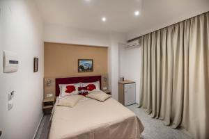 sypialnia z łóżkiem z 2 czerwonymi poduszkami w obiekcie Hotel Dimitra Sun w mieście Archangelos +37 zdjęć