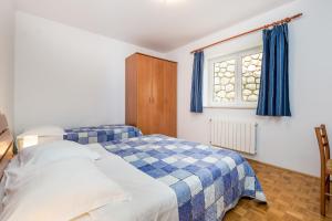 ein Schlafzimmer mit zwei Betten und einem Fenster in der Unterkunft Apartments Gea in Mošćenička Draga