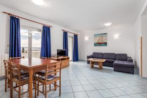 ein Wohnzimmer mit einer Couch und einem Tisch in der Unterkunft Apartments Gea in Mošćenička Draga