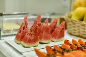 a group of watermelon slices on plates on a counter at Pianna Hotel in Buritis
