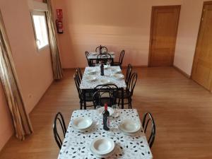 a dining room with tables and chairs with dishes on them at Residencial El Cuartel in Grañón