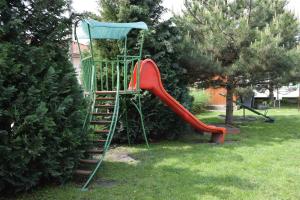 einen Spielplatz mit einer roten Rutsche im Hof in der Unterkunft Abturist penzion in Štúrovo