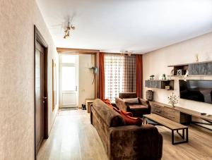 een woonkamer met een bank en twee stoelen bij Old Walls 1 in Tbilisi City
