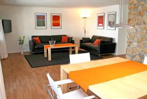 a living room with a couch and a table at Monami Apartments Klosters, Apt. Casa Selva Nr 10 in Klosters